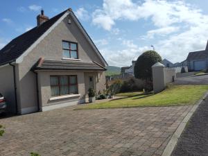 a house with a brick driveway in front of it at Divine Cottage in Ballycastle