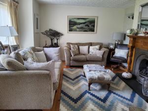 a living room with two couches and a fireplace at Divine Cottage in Ballycastle
