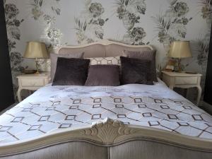 a bedroom with a large bed with two night stands at Divine Cottage in Ballycastle