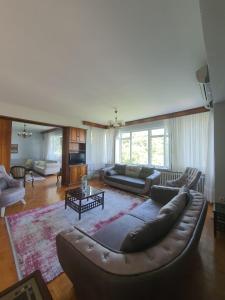 sala de estar amplia con sofá de cuero y mesa en شقة اطلالة كاملة على مدينة بورصة مع مسبح وسط المدينة en Çekirge