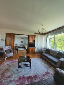 sala de estar con sofá y mesa en شقة اطلالة كاملة على مدينة بورصة مع مسبح وسط المدينة en Çekirge