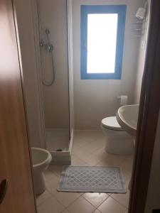 a bathroom with a shower and a toilet and a sink at Hotel Atlantic in Senigallia