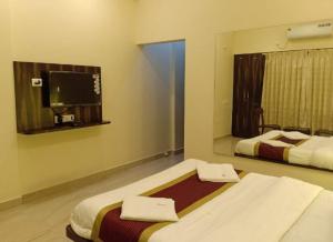 Katil atau katil-katil dalam bilik di Hotel Deepak Executive, Ganpatipule