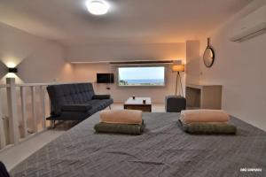 a bedroom with a large bed with a couch and a chair at Sisi seaview apartments in Sisi
