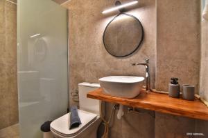 W łazience znajduje się umywalka, lustro i toaleta. w obiekcie Sisi seaview apartments w mieście Sisi