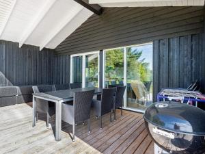 eine Terrasse mit einem Tisch und Stühlen auf einer Terrasse in der Unterkunft Holiday home Bindslev XXIII in Bindslev