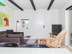 uma sala de estar com um sofá e uma televisão em Holiday home Bindslev XXIII em Bindslev