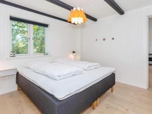 ein großes Bett in einem Zimmer mit weißen Wänden in der Unterkunft Holiday home Bindslev XXIII in Bindslev