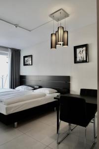 a bedroom with a bed and a desk and a chandelier at Super Stay Hotel, Oslo in Oslo