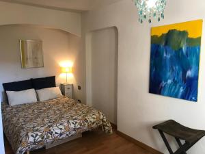 ein Schlafzimmer mit einem Bett und einem Gemälde an der Wand in der Unterkunft La Romarine in Falicon + 68 Fotos