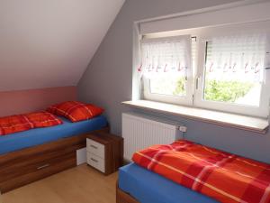 a attic bedroom with two beds and a window at Apartment Strandkorb by Interhome in Hooksiel