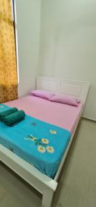białe łóżko z niebieskim kocem w obiekcie OLIA MEDINA KERTEH 4 BILIK HOMESTaY w mieście Kampong Kemaman