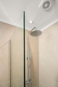 W łazience znajduje się prysznic ze szklanymi drzwiami. w obiekcie Nieva Apartment 1 w mieście Matala