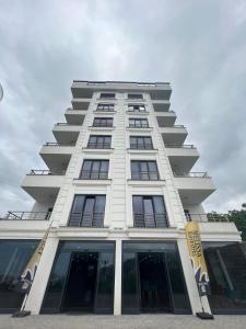 wysoki biały budynek z znakiem przed nim w obiekcie Melissa Suite Otel w mieście Trabzon