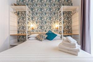 a bedroom with a white bed with blue and white pillows at Albergo Aquila in Rimini