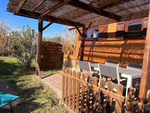 un patio en bois avec des chaises et une clôture en bois dans l'établissement La Roulotte du Mas, à Saintes-Maries-de-la-Mer 7 autres photos