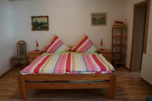 a bed with a colorful striped comforter in a room at Gästehaus Sehl in Senheim