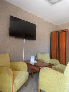 een wachtkamer met een tafel en stoelen en een flatscreen-tv bij Zajazd nad Zalewem Dzibice -Pensjonat, Agroturystyka in Dzibice