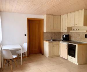 a kitchen with wooden cabinets and a table and chairs at Große Wohnung mit 2 Schlafzimmern in Altensteig