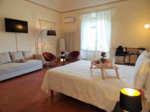 - un salon avec un lit blanc et un canapé dans l'établissement Palazzo Rosselmini, à Pise