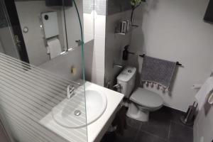 a bathroom with a sink and a toilet and a mirror at CADUCÉE Studio balcon ensoleillé parking nord Montpellier in Grabels