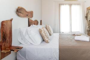 een slaapkamer met een bed met witte lakens en kussens bij Tethys 2 by Cretan Pnoe Adults Only in Chania