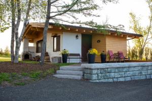 une petite maison avec 2 chaises et une terrasse couverte dans l'établissement Edelweiss Inn Nova Scotia, à Middleton