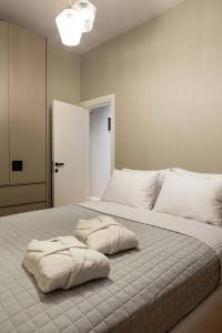 a bedroom with a large bed with two pillows on it at ICONIC SALONICA SUITE seafront in Thessaloniki