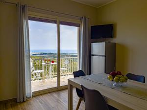a kitchen with a table and a view of a balcony at Athena Agrigento Apartments in Agrigento