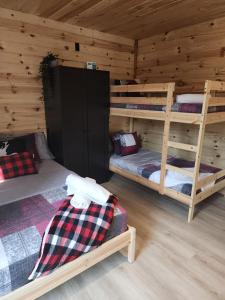 a room with two bunk beds in a log cabin at Spa calme au sommet in Saint Come