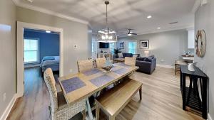 comedor y sala de estar con mesa de comedor en Sea La Vie Beach Cottage 3b2b - 2 Pools, en Gulf Shores