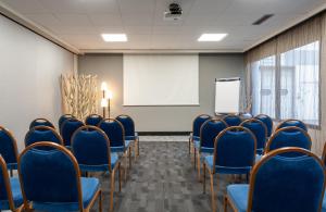 una sala de conferencias con sillas azules y una pizarra en Kyriad - Créteil - Bonneuil-sur-Marne, en Bonneuil-sur-Marne