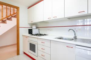 een keuken met witte kasten en een spoelbak bij Duplex Sorolla in La Venteta