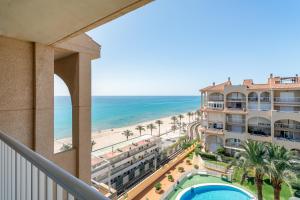uitzicht op het strand vanaf het balkon van een resort bij Duplex Sorolla in La Venteta