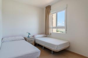 twee bedden in een kamer met een raam bij Duplex Sorolla in La Venteta +15 foto's