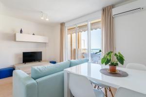 een woonkamer met een blauwe bank en een tafel bij Duplex Sorolla in La Venteta