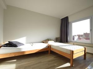 dwa łóżka w pokoju z oknem w obiekcie Du Parc 00006 Spacious apartment in De Haan w mieście De Haan