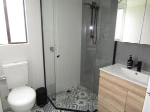 a bathroom with a shower and a toilet and a sink at L'il Southshore in Brentwood