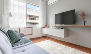 uma sala de estar com um sofá cinzento e uma televisão em Tabas - Lindíssimo apê 3 quartos na Lagoa - LG0006 no Rio de Janeiro