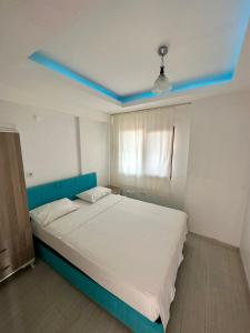 a bedroom with a large bed with a blue headboard at Koparan Apart Hotel in Akyaka