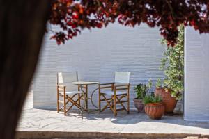 a patio with a table and two chairs and a wall at Lemoni House in Andros