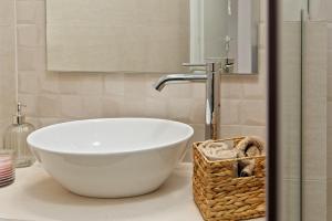 La salle de bains est pourvue d'un grand lavabo blanc sur un comptoir. dans l'établissement Lemoni House, à Andros