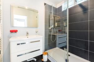 W łazience znajduje się biała umywalka i prysznic. w obiekcie Le Cottage de l'Hippodrome. w mieście Lambersart