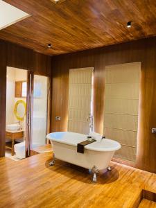 een grote badkamer met een bad en een wastafel bij The Postcard Saligao in Calangute