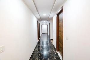 un pasillo largo con suelo de mármol y paredes blancas en FabHotel Silver Crown, en Nueva Delhi