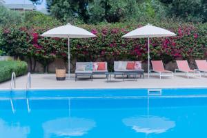 2 sillas y sombrillas junto a una piscina en Villa Luisa, en Bari