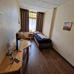 Zimmer mit einem Bett und einem Schreibtisch mit einem Computer in der Unterkunft Gasthaus Pension DÖRENKRUG - Restaurant in Augustdorf