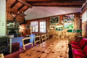 sala de estar con mesa de madera y chimenea en Casa al Fiume by Quokka 360 - House by the River in the Verzasca Valley en Lavertezzo
