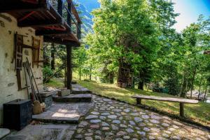 a stone walkway next to a building with a bench at Casa al Fiume by Quokka 360 - House by the River in the Verzasca Valley in Lavertezzo