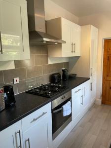 a kitchen with white cabinets and a stove top oven at 18 Horner Street in York +16 photos